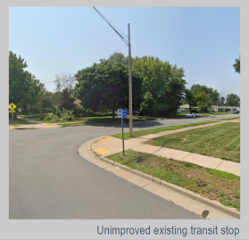 Photo of an Unimproved Bus Stop. A blue bus stop sign is posted in the grassy boulevard at an intersection