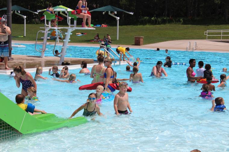 Picture of kids and adults playing in swimming pool.