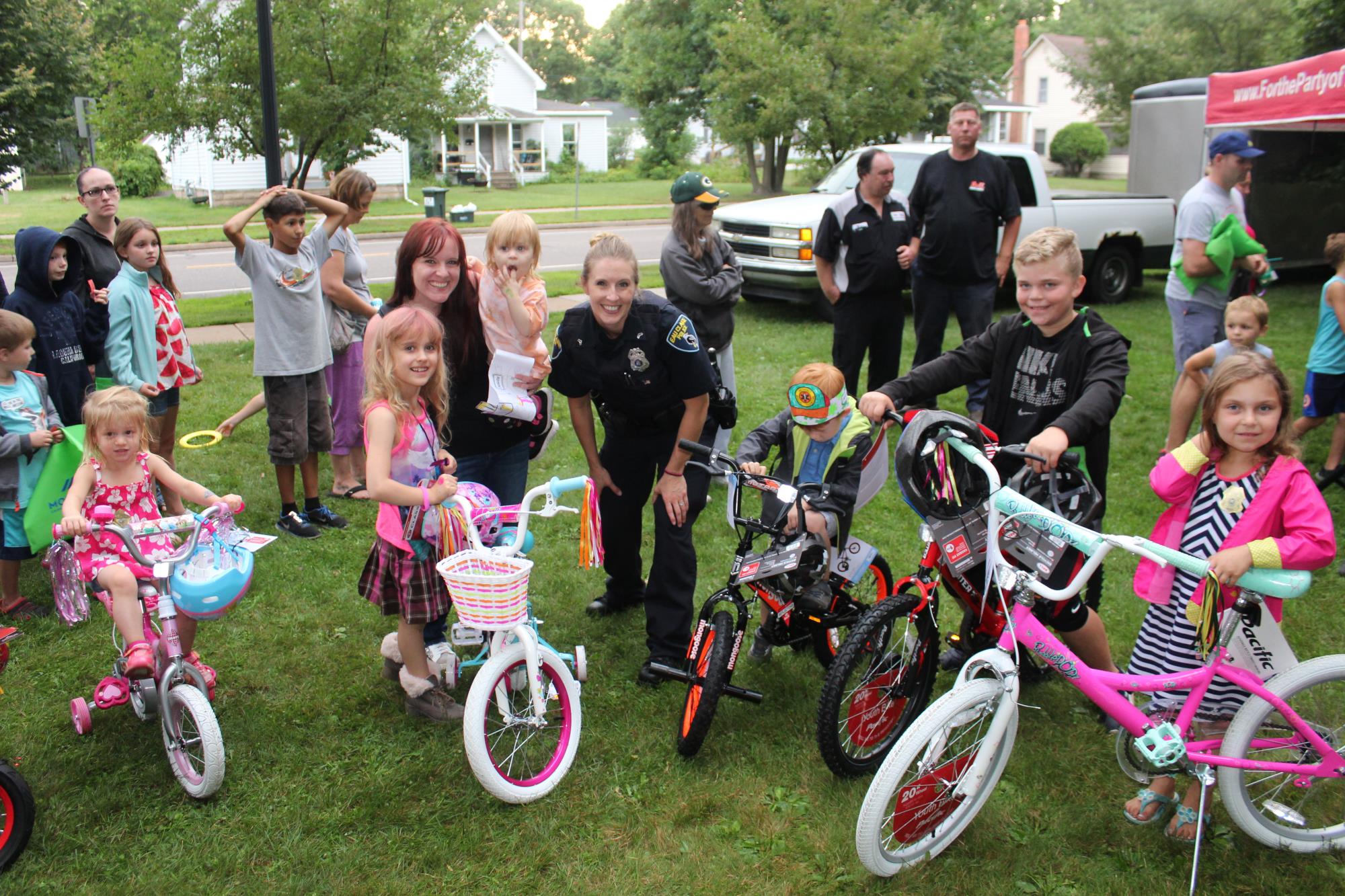 Photo of a female Eau Claire Police Department officer posing with children on bicycles