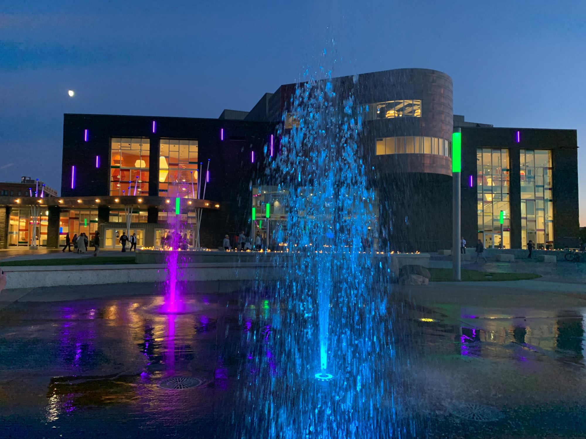 A decorative picture of Haymarket Plaza fountain at night with purple and blue lights.